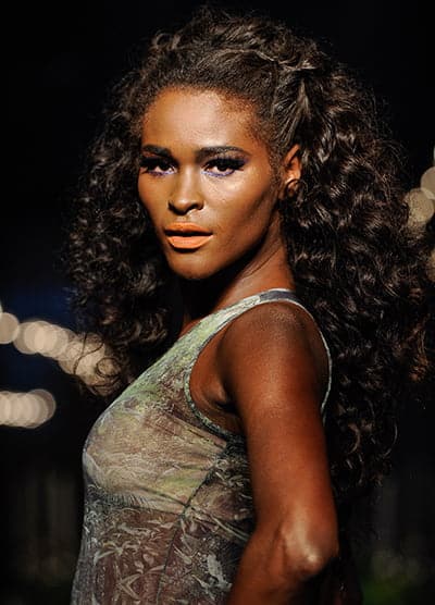 Lábios alaranjados + olhos com contorno roxo.