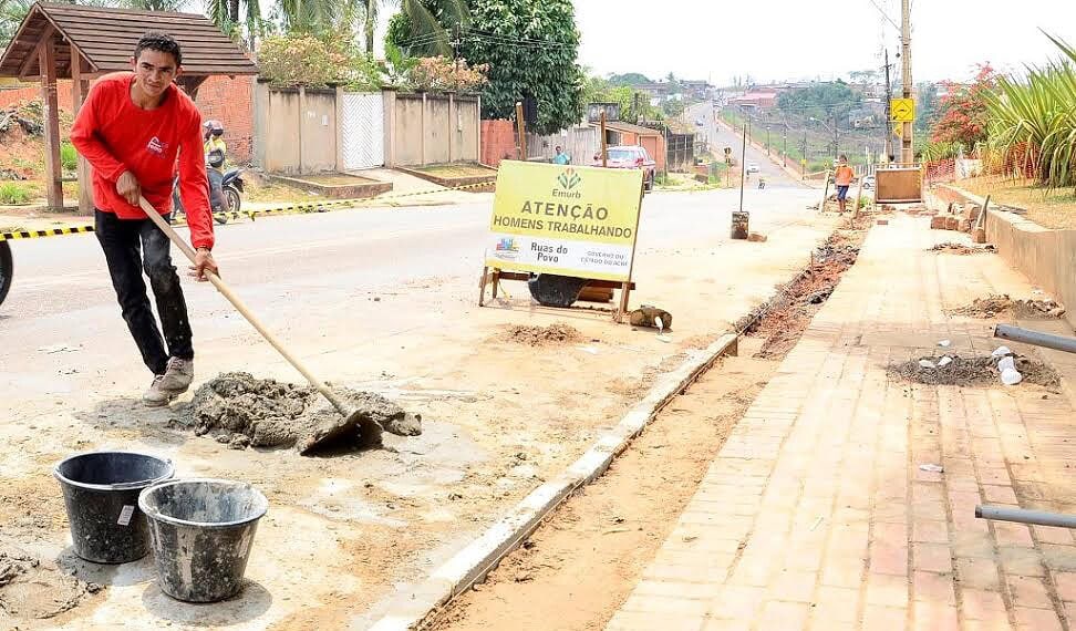 Estudantes caminham por calçada em construção na periferia