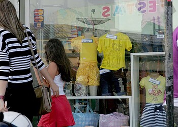 Mãe e filha pesquisam preços em loja especializada em moda jovem, ontem