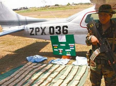 Soldado posa ao lado de aeronave e dos entorpecentes: brasileiro está entre presos