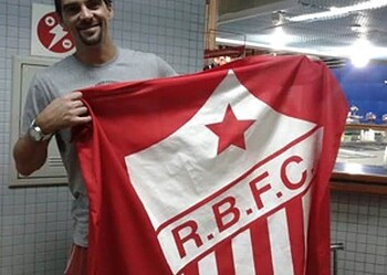 No aeroporto de Rio Branco, o ex-jogador de vôlei Giba tira foto com a bandeira do Rio Branco