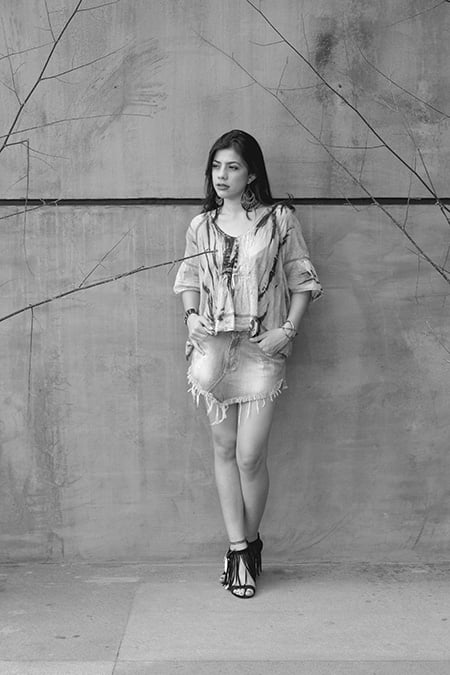 A minissaia assimétrica jeans justa compõe muito bem com a bata ampla tiedye, dando uma proporção adequada ao look. As sandália de franjas e o maxi brinco dão o tempero especial.  